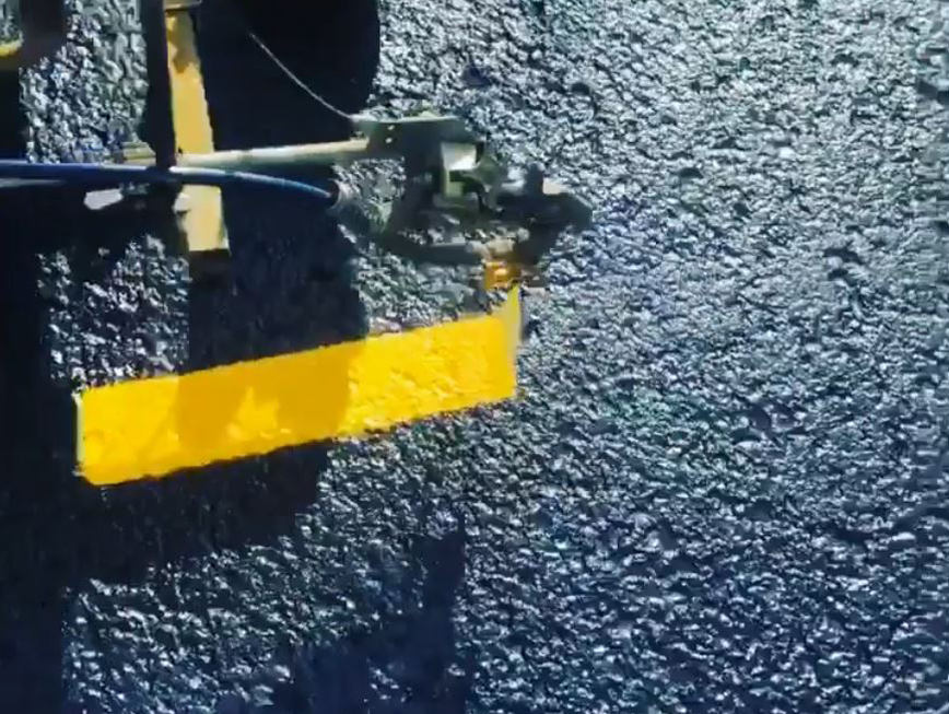 close up of parking lot lines being painted