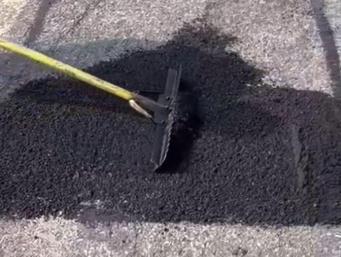 raking out asphalt for a pot hole repair