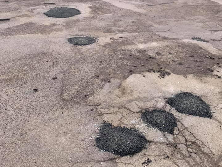 pot holes filled in with asphalt in a parking lot
